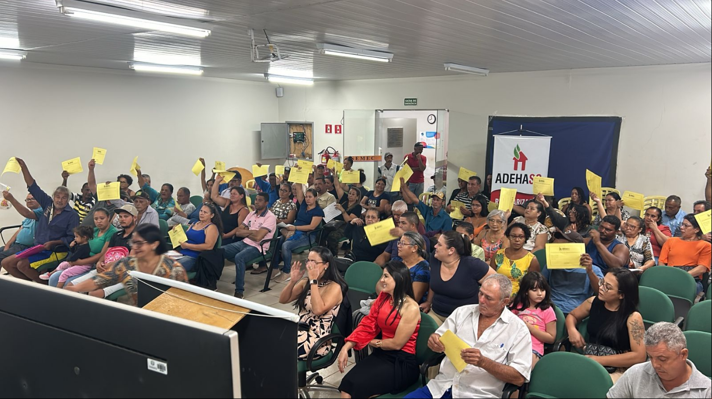 Ocupantes com as mãos erguidas demonstrando interesse na regularização de seus lotes.